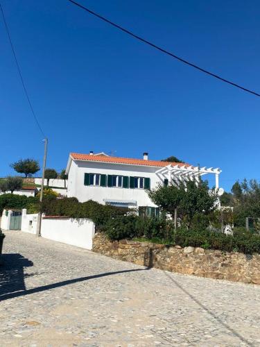 a large white building in front of a building at Refugio Abrunheiro Grande in Vila de Rei