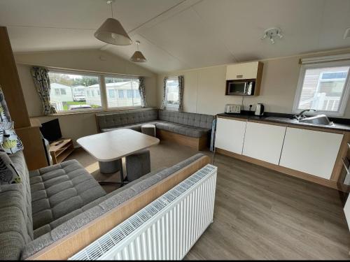 a living room with a couch and a table at Sycamore Caravan in Helston