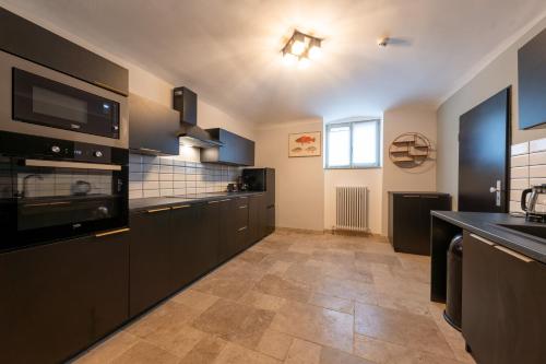 a large kitchen with black cabinets and a tile floor at Design Apartments - "Villa Arnim" in Potsdam