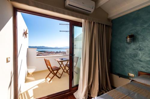 a bedroom with a balcony with a view of the ocean at Le Tre Caravelle in SantʼAntìoco