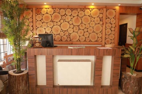 a room with a tv and a wall of logs at The Woodlands Residency- Unmarried and stag groups not allowed in Ooty