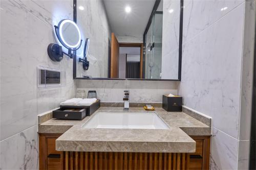 a bathroom with a large sink and a mirror at VM Hotel in Phnom Penh