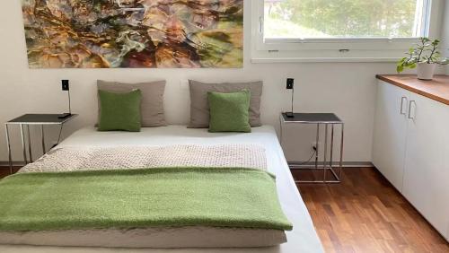 een slaapkamer met een bed met een groene deken erop bij Ferienwohnung Chasa Splerin mit Whirlpool auf Terrasse in Scuol