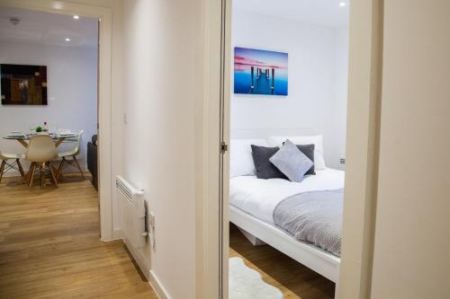 um quarto com uma cama branca e uma mesa em Luxury 2 Bed Apartment em Manchester