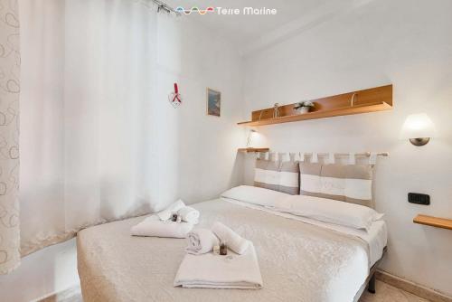 ein weißes Schlafzimmer mit 2 Handtüchern auf dem Bett in der Unterkunft Il Nido delle Cinque Terre in Volastra