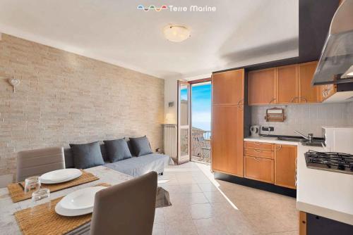 eine Küche und ein Wohnzimmer mit einem Sofa und einem Tisch in der Unterkunft Il Nido delle Cinque Terre in Volastra