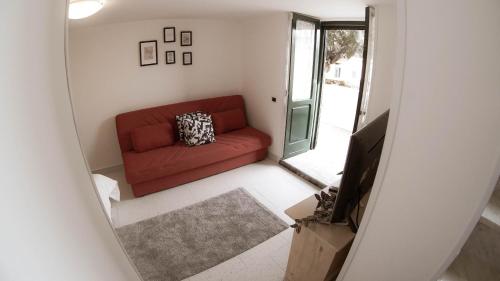 a living room with a red couch and a television at Casa nel borgo dei gatti in Cetara