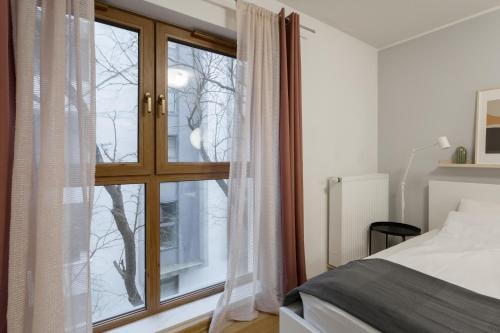 sypialnia z dużym oknem i łóżkiem w obiekcie Studio w centrum- Villa Wenecja w Poznaniu