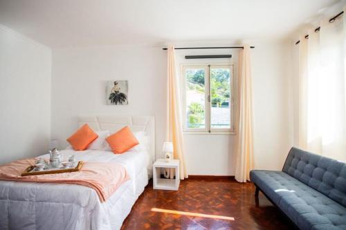 um quarto com uma cama, um sofá e uma janela em Dream Paradise em Água de Pena