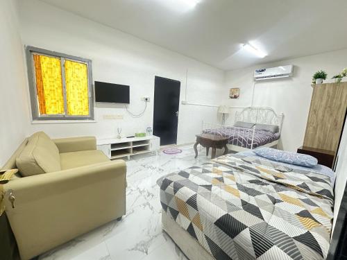a living room with a bed and a couch at Comfy Studio Apartment in Abu Dhabi