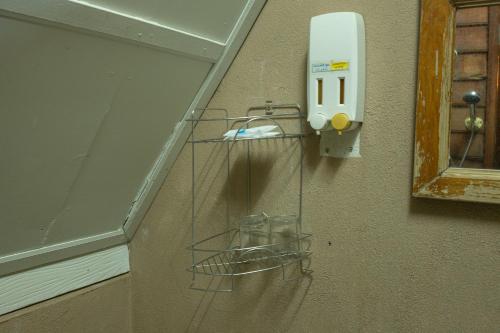 a wire shelf on a wall with a soap dispenser at RoomQuest Golden Triangle Premium Collection in Chiang Saen