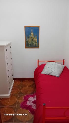 a bedroom with a red bed and a dresser at Il Pianello in Poppi