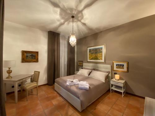 een slaapkamer met een bed, een tafel en een bureau bij B&B Civico 58 in Pannocchia