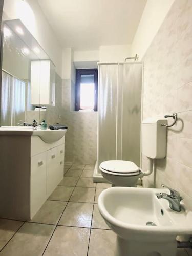Baño blanco con aseo y lavamanos en Casa Milano, Como, Varese, en Cislago