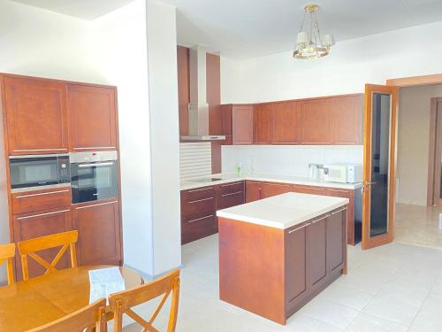 a kitchen with wooden cabinets and a table in it at Hotel Burabay in Shchūchīnsk
