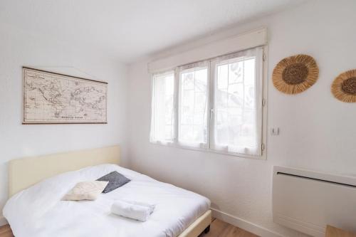 a white bedroom with a bed and a window at Studio le charme Breton - Saint-Brieuc in Saint-Brieuc