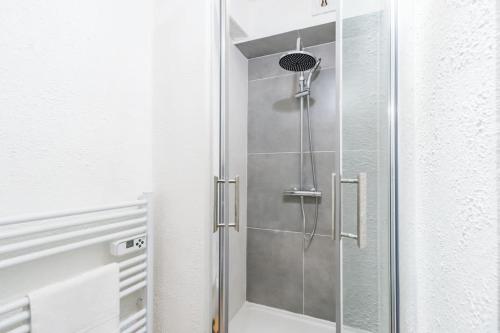 La salle de bains est pourvue d'une douche avec une porte en verre. dans l'établissement Studio le charme Breton - Saint-Brieuc, à Saint-Brieuc