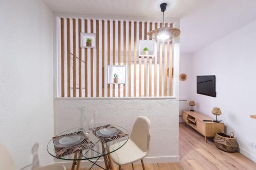 une salle à manger avec une table en verre et des chaises blanches dans l'établissement Studio le charme Breton - Saint-Brieuc, à Saint-Brieuc