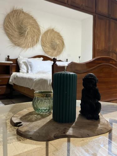 a table with a green vase on top of a bed at Dar louzir à Tazarka in Tazarka