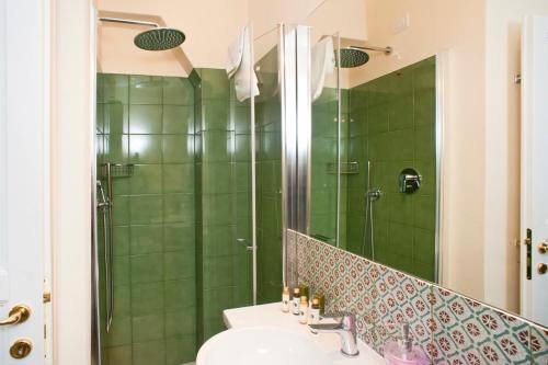 a bathroom with a green tiled shower and a sink at Residenza Ca De Frati in Arezzo