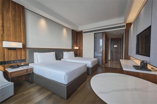 a hotel room with two beds and a television at VM Hotel in Phnom Penh