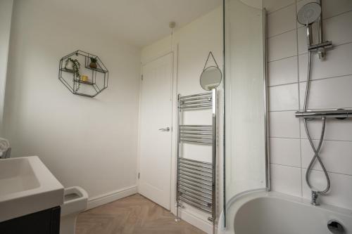 een badkamer met een douche en een bad bij Wallington House By Horizon Stays in Stockton-on-Tees