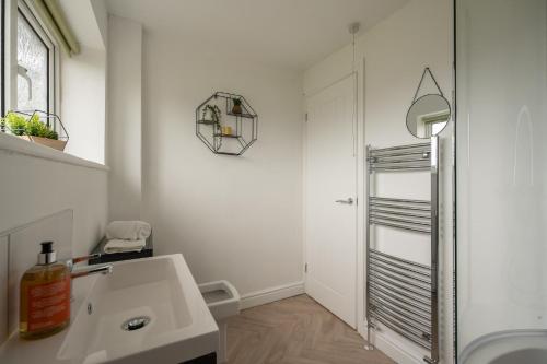 een witte badkamer met een wastafel en een spiegel bij Wallington House By Horizon Stays in Stockton-on-Tees