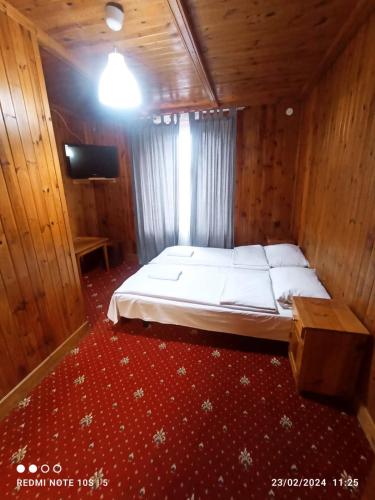 a bedroom with a bed in a wooden room at Green House in Wola Przypkowska