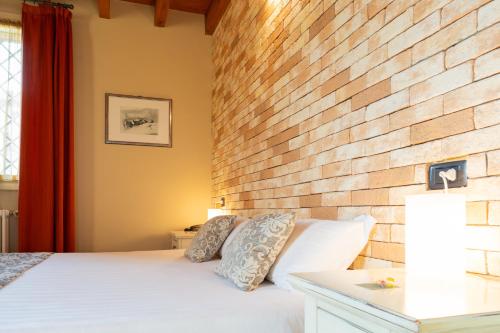 a bedroom with a brick wall and a bed at Agriturismo La Razza in Reggio Emilia
