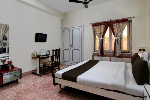 een slaapkamer met een bed en een bureau. bij OYO Brothers Inn in kolkata