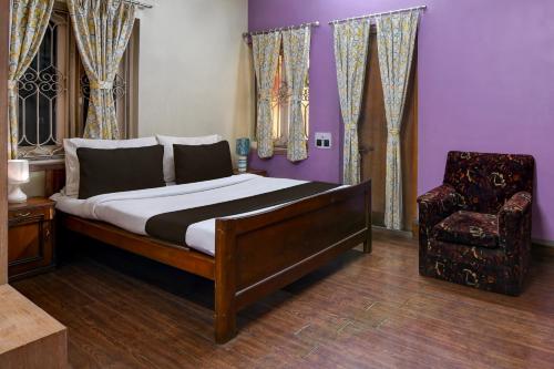 um quarto com uma cama e uma cadeira em OYO Brothers Inn em kolkata