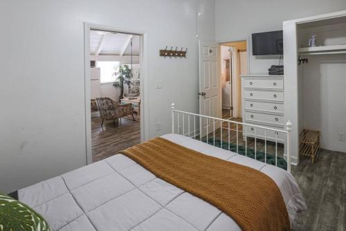 a bedroom with a bed and a dresser and a mirror at Blackbeards Rendezvous Downtown Danish Villa in Christiansted