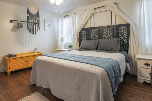 Schlafzimmer mit einem großen Bett mit einem schwarzen Kopfteil in der Unterkunft The Roosters Perch - A Quaint Island Homestead in Christiansted