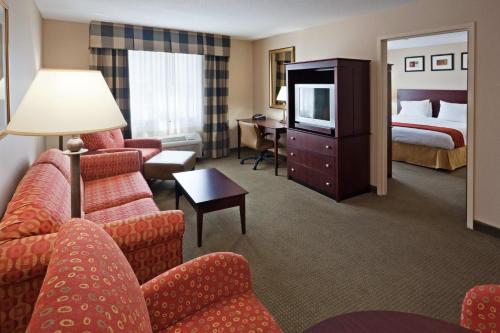 a hotel room with a bed and a living room at Holiday Inn Express Hotel & Suites Freeport, an IHG Hotel in Freeport