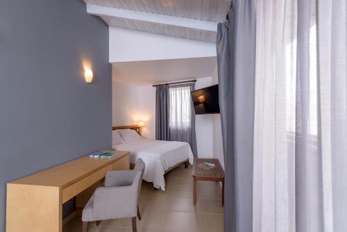 a hotel room with a bed and a desk and a chair at Iraklion Hotel in Heraklio Town