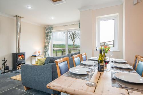 a dining room with a table and a fireplace at RURAL RETREAT WALES Indoor Hot Tub, Log Fire, Starry Skies, Woodland Walks in Llanfyrnach