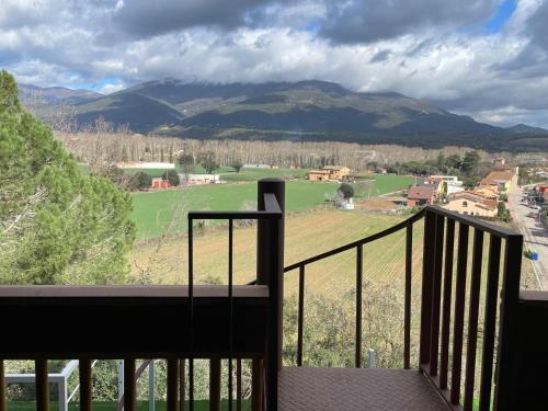 a balcony with a view of a green field and mountains at Les Suites in Santa María de Palautordera