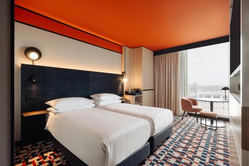 a hotel room with a bed and a large window at DoubleTree by Hilton Amsterdam Centraal Station in Amsterdam