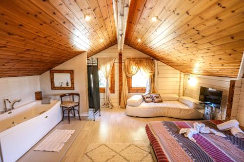 a large room with a bed and a bath tub at Les Suites in Santa María de Palautordera