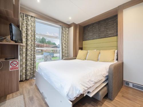 a bedroom with a large bed and a tv at Swallow in Penrith