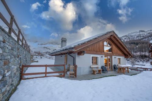 una piccola casa con neve per terra di FAIRWAY LODGE a Breuil-Cervinia