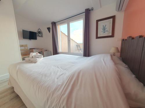 Ένα ή περισσότερα κρεβάτια σε δωμάτιο στο Hôtel Les Calanques