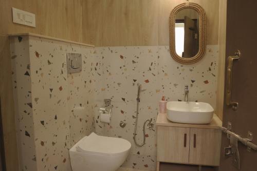 uma casa de banho com um WC, um lavatório e um espelho. em Bungalow Eleven11 em Jaipur