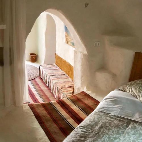 - une chambre avec un lit et une voûte dans l'établissement Maison D'hote Dar Jeddi, à Kreddache