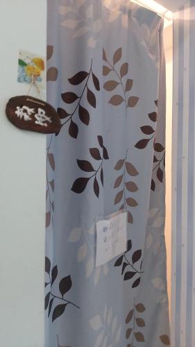 a shower curtain with a leaf pattern on it at Haven Seaview Homestay in Lanyu