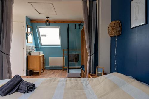 um quarto com uma cama e uma parede azul em Maisonnette & Jacuzzi em Saint-Valery-sur-Somme