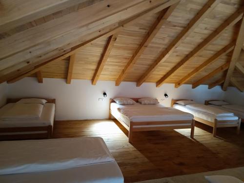 a attic room with three beds and wooden ceilings at Vikendica Krcmarice- Banja Luka in Banja Luka