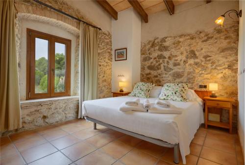 a bedroom with a bed and a stone wall at Mas Ramades in L'Estartit