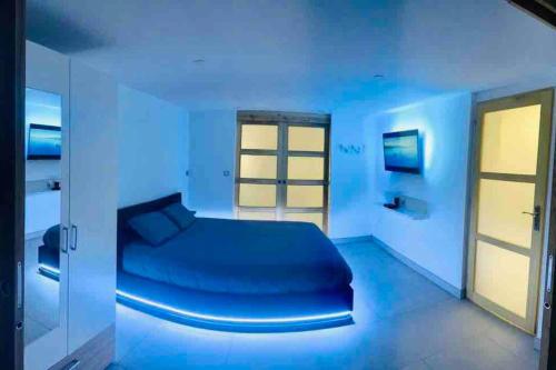 um quarto azul com uma cama num quarto em Appartement d'une chambre avec vue sur le lac terrasse amenagee et wifi a Excenevex em Excénevex