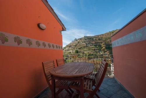 a wooden table and chairs on a balcony at Luxury Seaview Apartments Manarola by Arbaspàa in Manarola